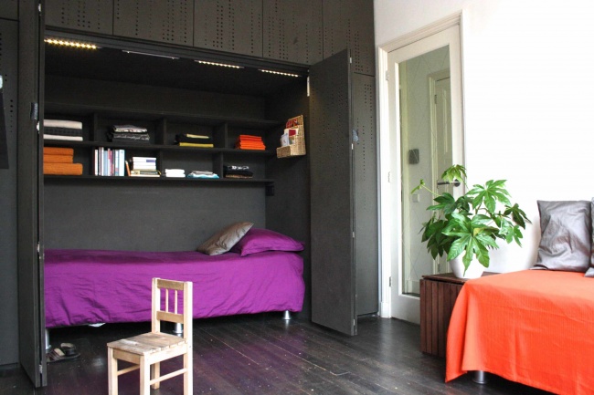 334905-r3l8t8d-650-space-saver-beds-with-purple-bedding-and-built-in-bookshelves-also-cabinets-with-dark-wood-flooring-and-indoor-plant-plus-day-bed-bedding