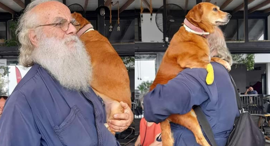 Ένας ιερέας διαφορετικός από τους άλλους στην Λέσβο: Κουβαλάει στα χέρια μια σκυλίτσα που έχει πρόβλημα με τη μέση της