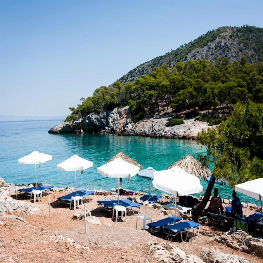 Είναι μια ανάσα από την Αθήνα, η είσοδος είναι δωρεάν, τα νερά της είναι καταγάλανα και τα δέντρα ακουμπούν στη θάλασσα