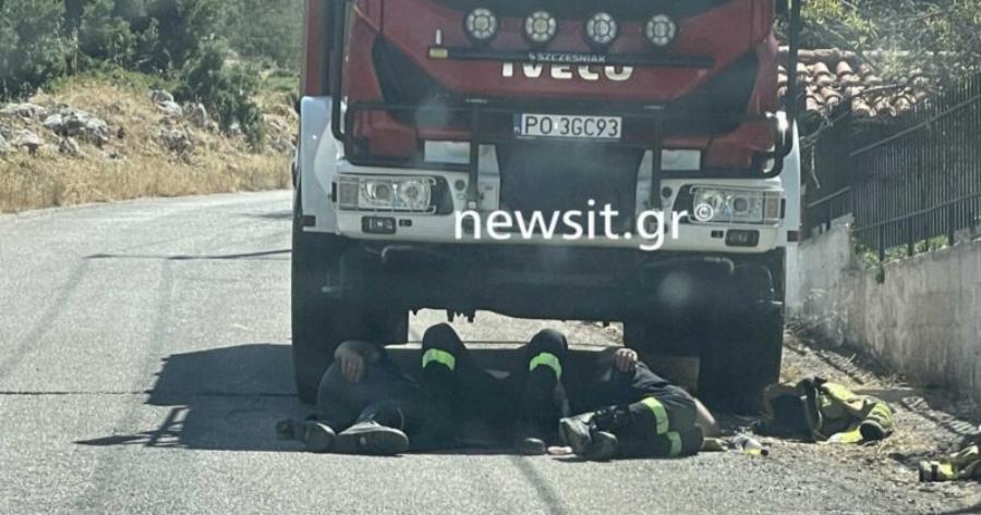 Βίλια: Πολωνοί πυροσβέστες ξεκουράζονται στη σκιά του πυροσβεστικού οχήματος μετά από μάχη με τις φλόγες