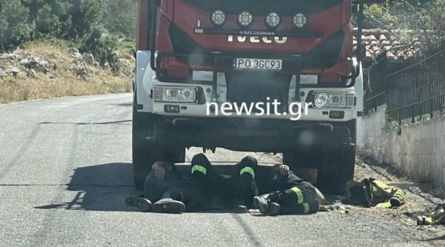 Βίλια: Πολωνοί πυροσβέστες ξεκουράζονται στη σκιά του πυροσβεστικού οχήματος μετά από μάχη με τις φλόγες