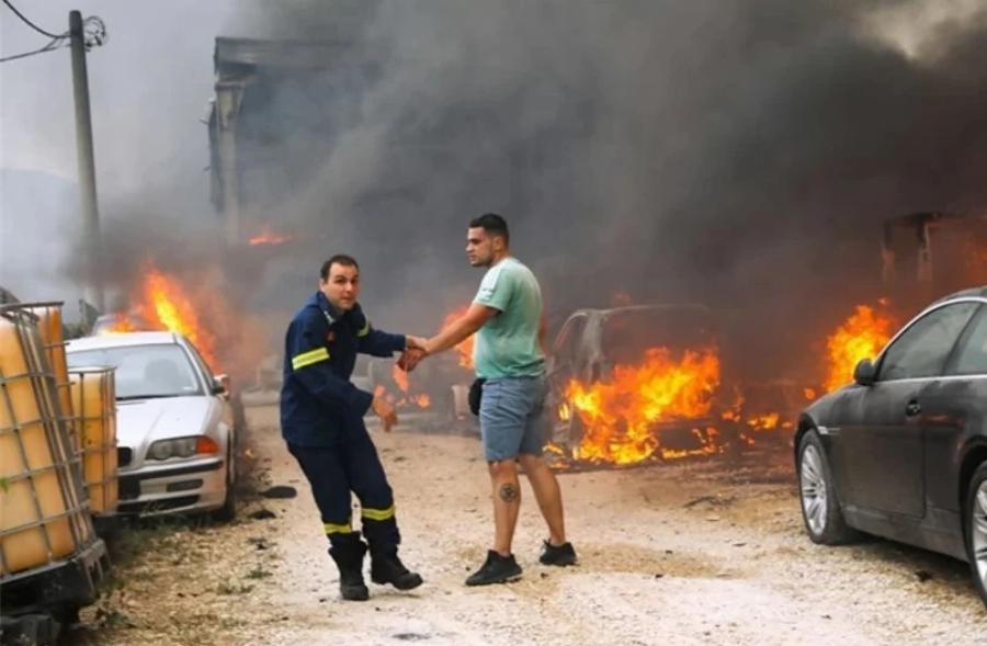 Πυροσβέστης παίρνει σηκωτό ιδιοκτήτη μάντρας αυτοκινήτων που τυλίγεται στις φλόγες