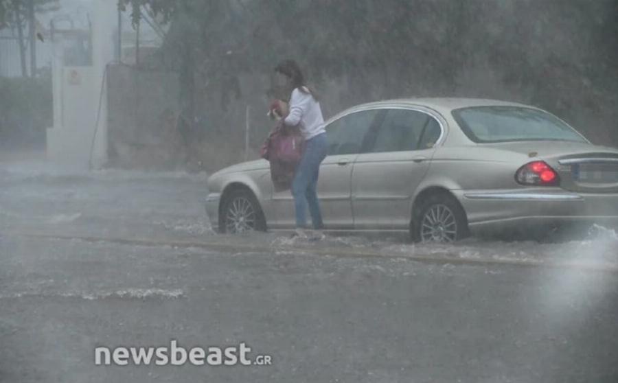 Έντρομη γυναίκα εγκαταλείπει το αυτοκίνητο στη μέση του δρόμου στην πλημμυρισμένη Πειραιώς